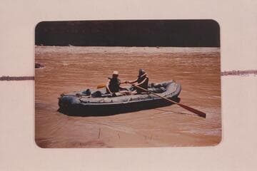 Elgin Pierce and Georgie White in their neoprene raft at Vulcan Rapid on the traverse of the Grand Canyon in 1952, July. Georgie White handled the oars for the trip